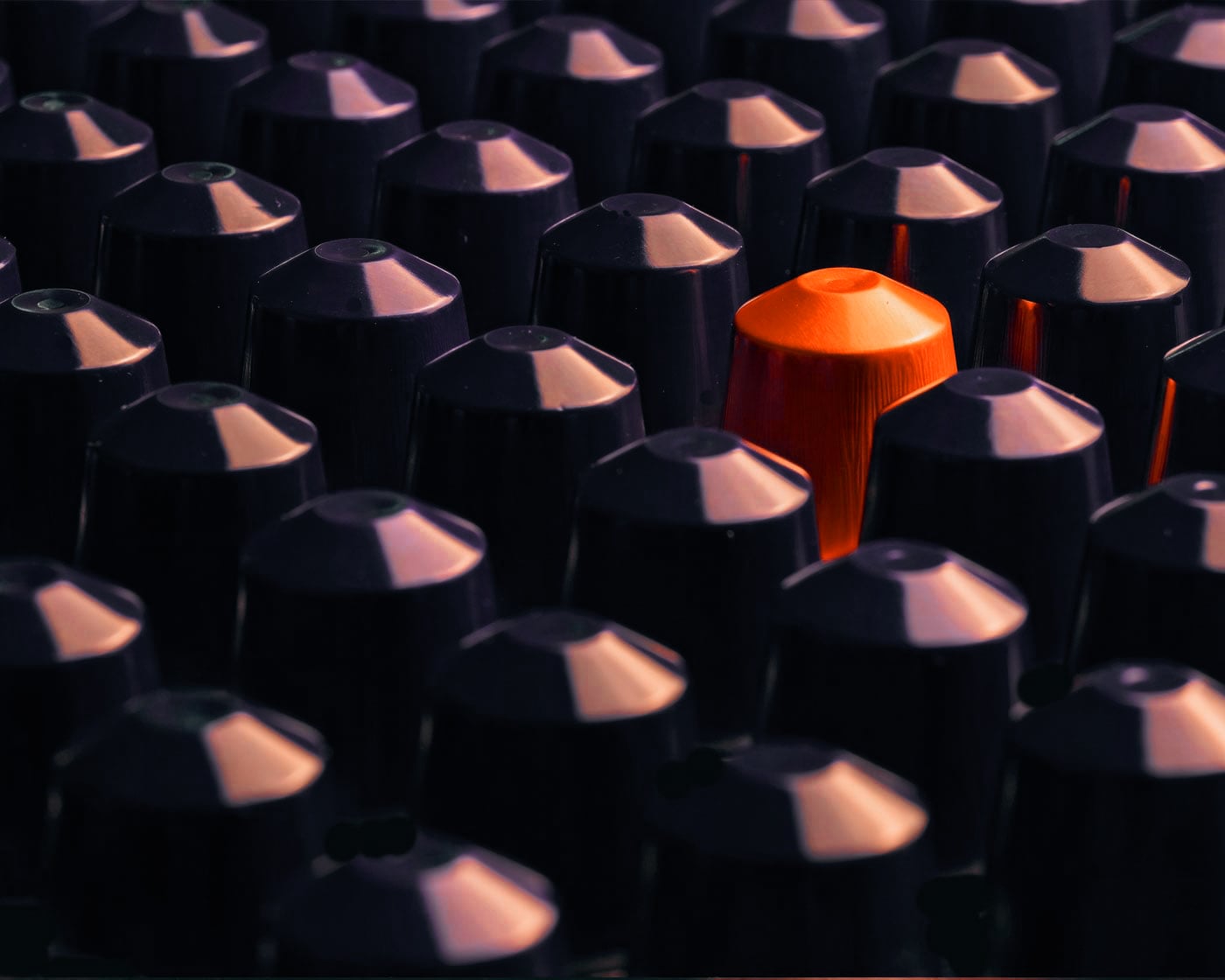 Shot of one orange pod standing out in a sea of other blue pods.